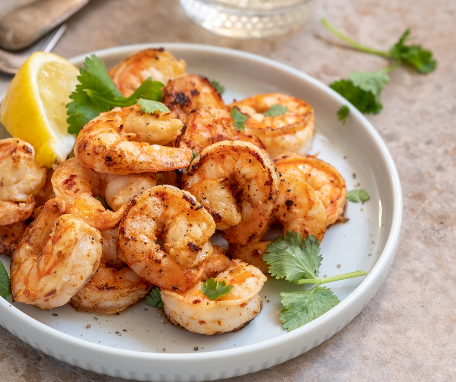 Juicy garlic butter shrimp served on a white plate, garnished with fresh parsley and lemon slices, accompanied by a side of steamed rice